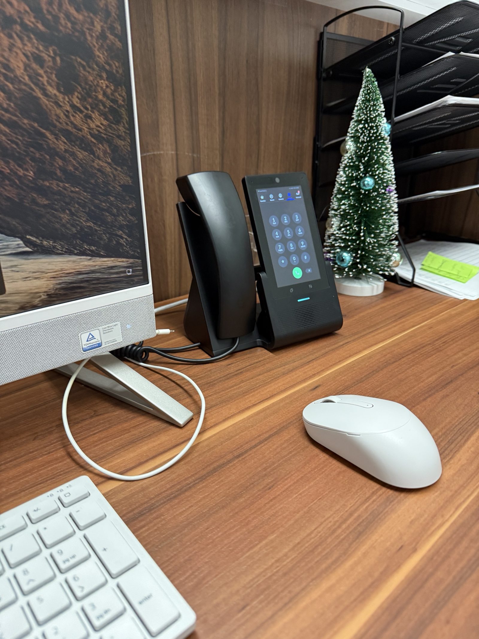 Touchscreen desk phone at a clinic front desk, provisioned before it reached the desk. Sheepshead Bay.